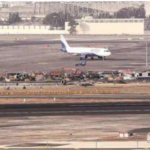 Aircraft at Mumbai Airport with maintenance crews working on the runway before monsoon season.